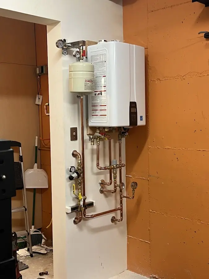 Plumbing technician inspecting water heater connections in La Blanca
